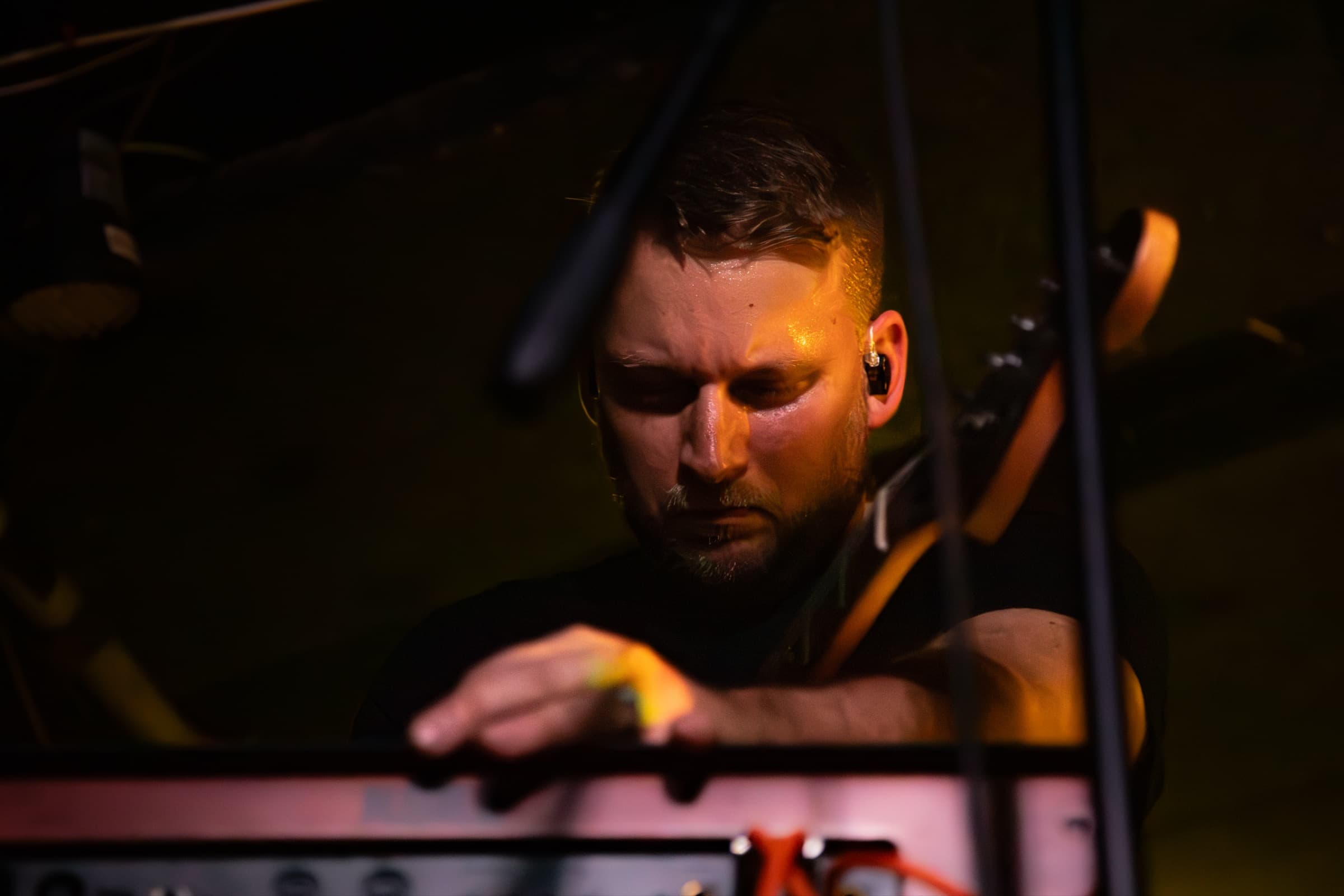 Tom Doesburg focused over keys in amber light.