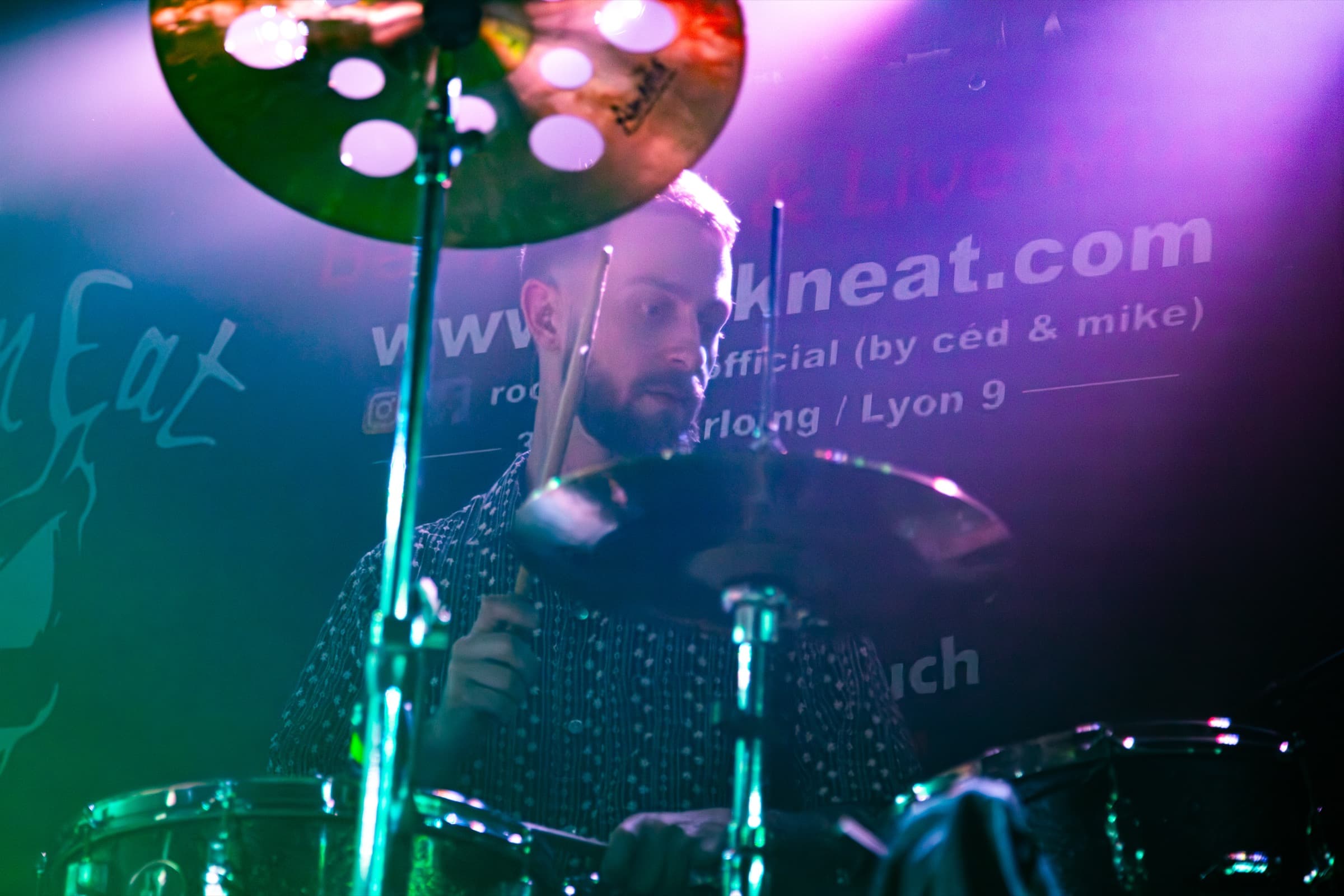 Benoît Durbet framed by cymbals and colored haze.